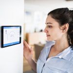 Woman Looking At Home Thermostat